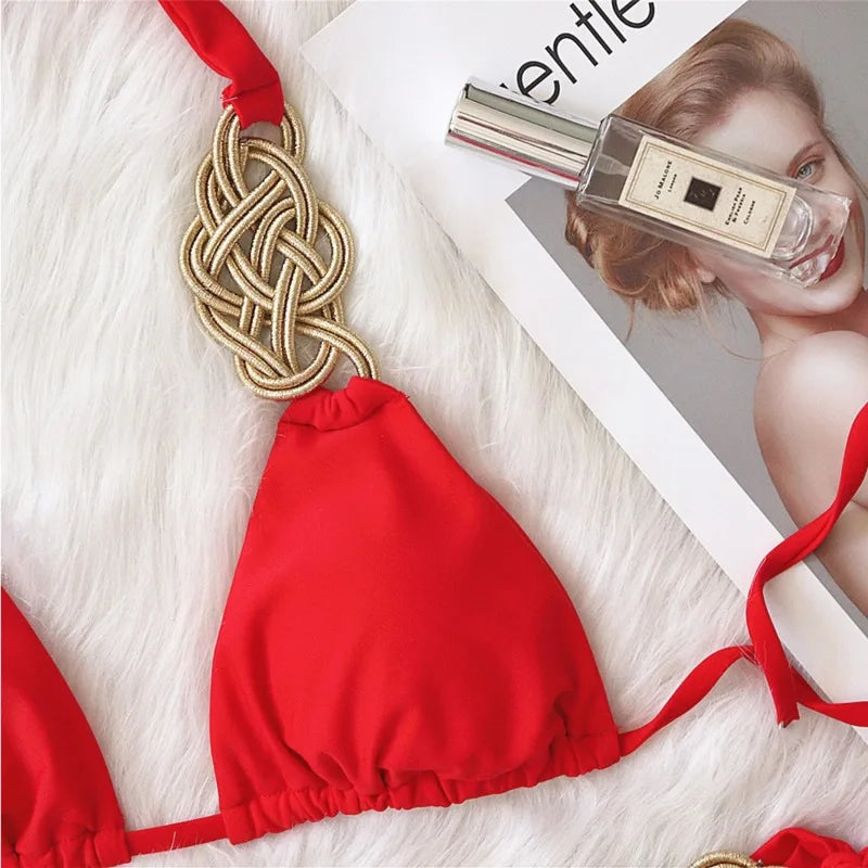 Bikini nero Brasiliano ASKATE 2025 con nodi oro decorativi, top a triangolo wire‑free e slip low‑waist, elegante e femminile.