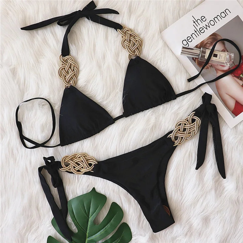 Bikini nero Brasiliano ASKATE 2025 con nodi oro decorativi, top a triangolo wire‑free e slip low‑waist, elegante e femminile.