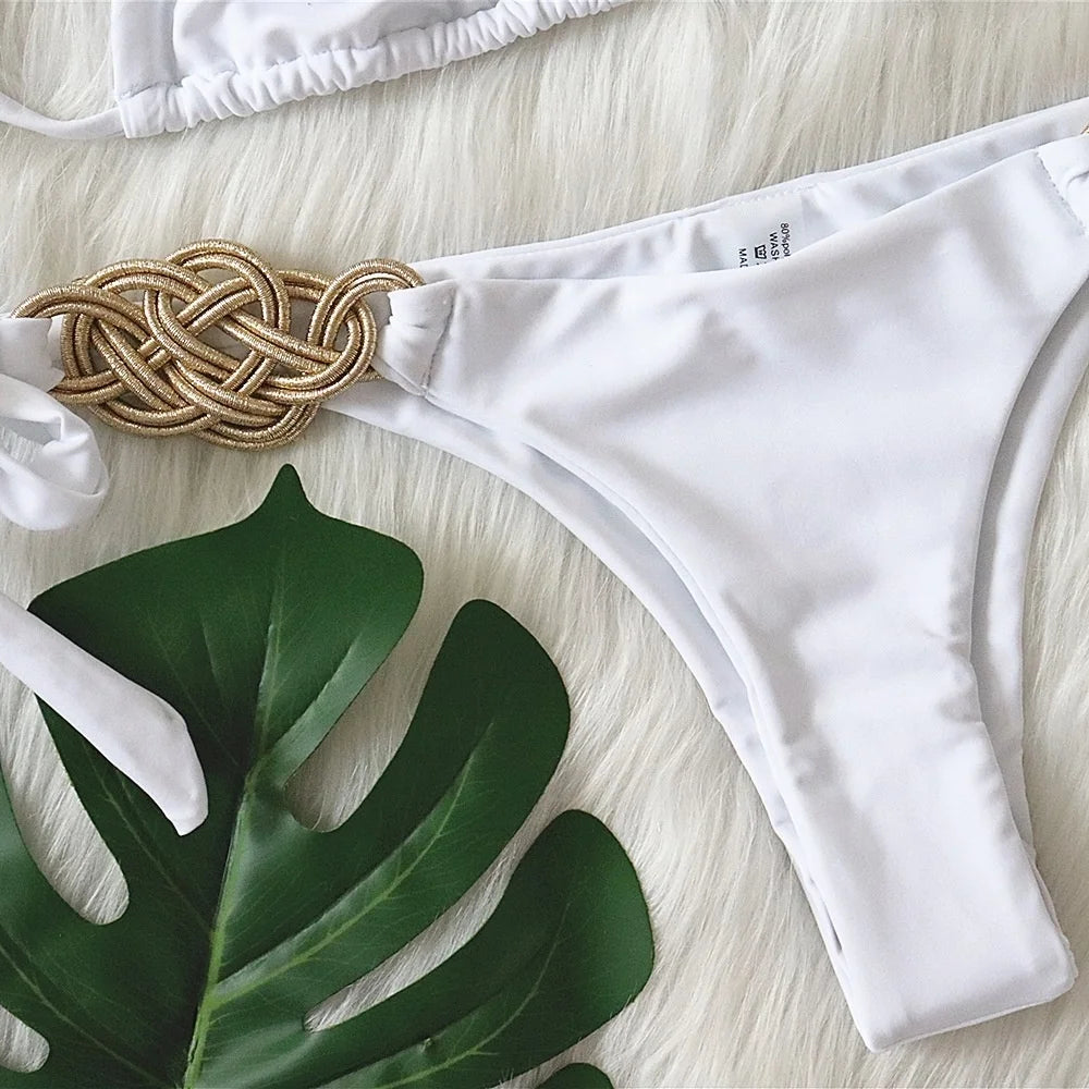 Bikini Brasiliano ASKATE 2025 con nodi oro decorativi, top a triangolo wire‑free e slip low‑waist, elegante e femminile.