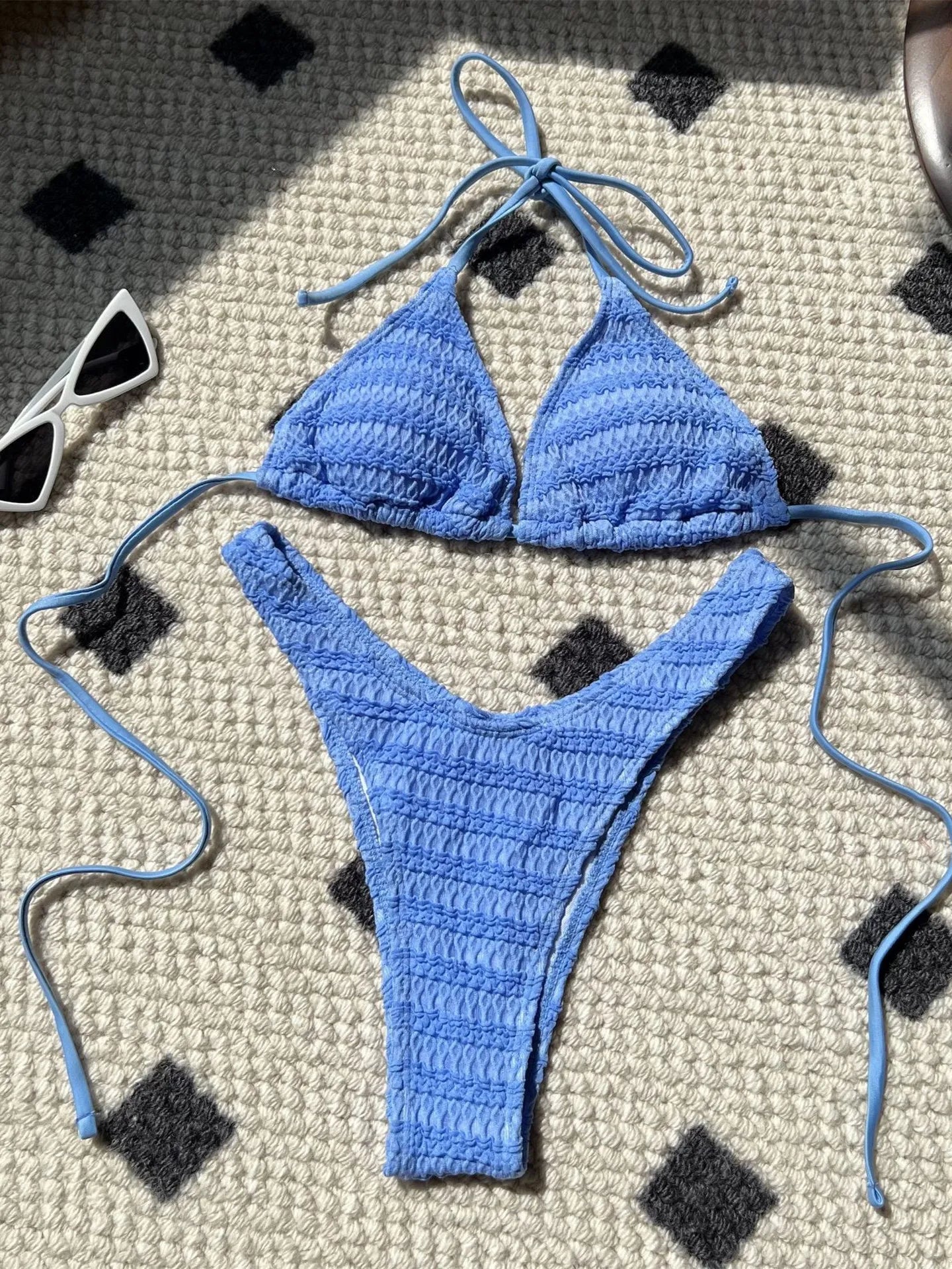 Bikini donna lavorato all'uncinetto in stile crochet, colore azzurro lago, con top a triangolo e slip a V, ideale per l'estate 2025. Design boho chic con laccetti regolabili.