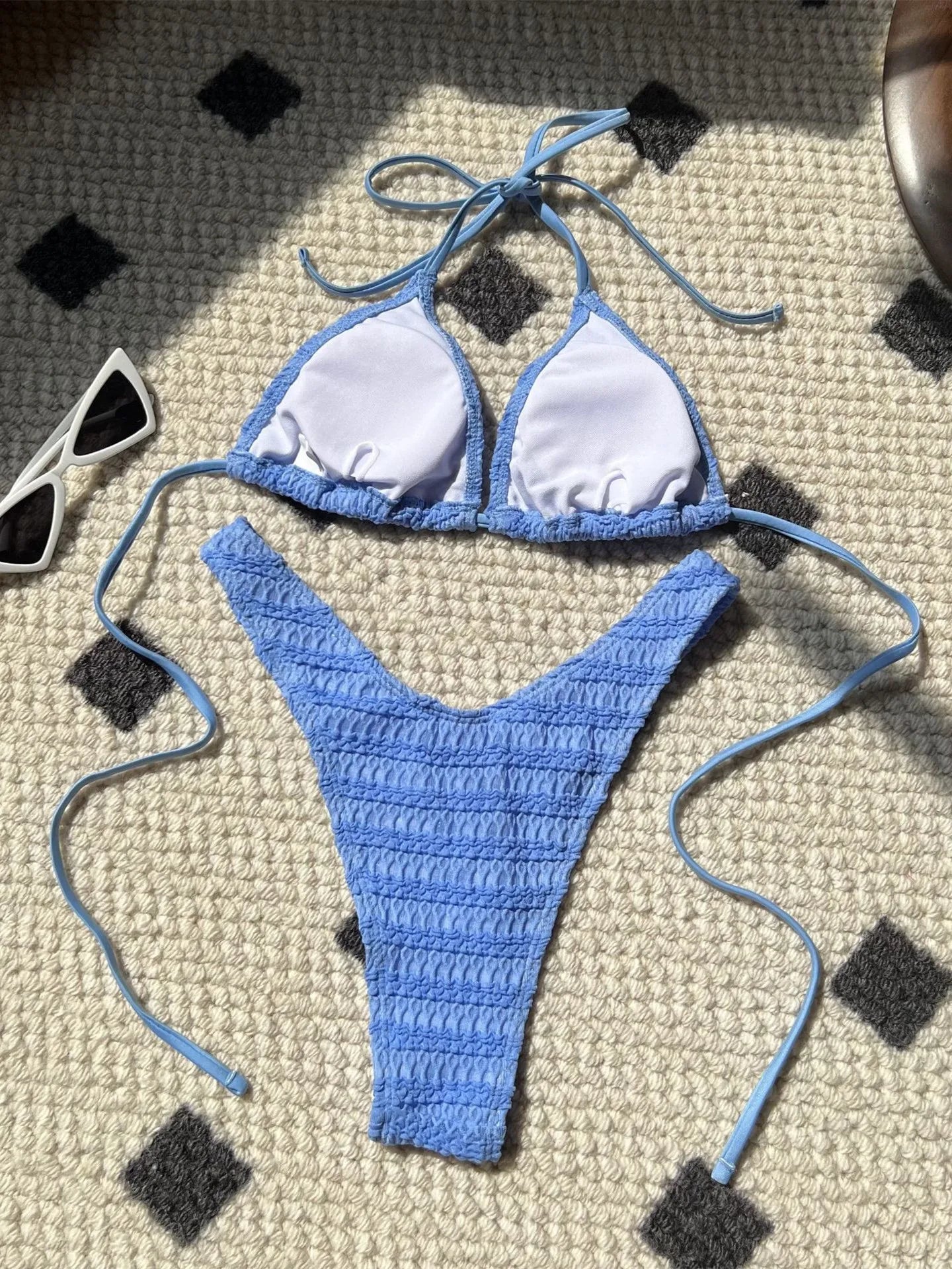 Bikini donna lavorato all'uncinetto in stile crochet, colore azzurro lago, con top a triangolo e slip a V, ideale per l'estate 2025. Design boho chic con laccetti regolabili.