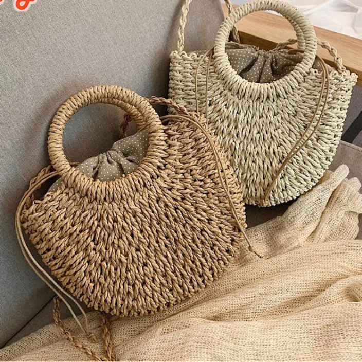Borsa paglia intrecciata semicircolare in paglia naturale, beige e khaki, con manici rotondi e versione con fiocco Ribbon, vista frontale su fondo neutro