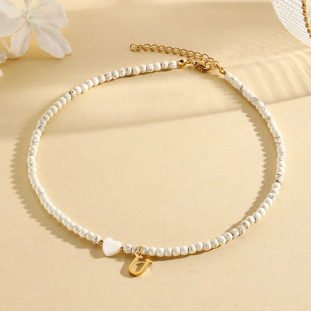 Choker boho con perline, cuore in conchiglia e iniziale in acciaio – collana personalizzata stile 2025