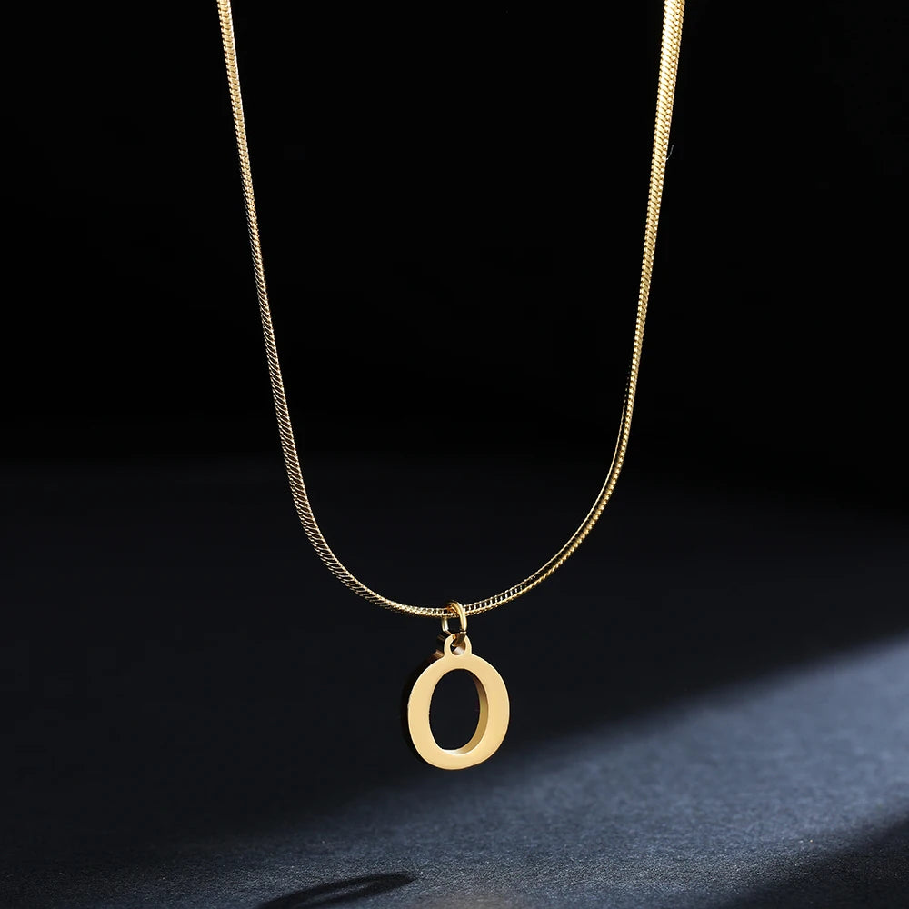 Collana iniziale A–Z in acciaio placcato oro con snake chain – pendente minimal su collare clavicolare