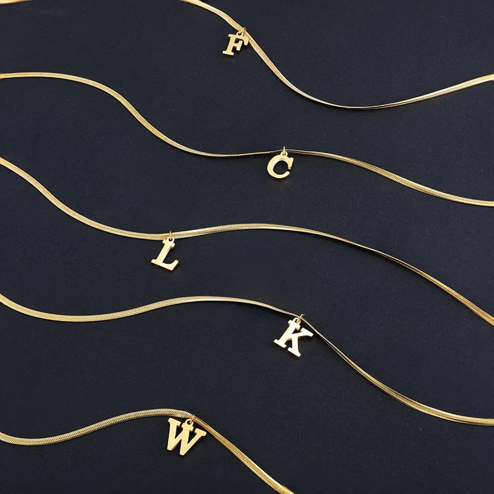 Collana iniziale A–Z in acciaio placcato oro con snake chain – pendente minimal su collare clavicolare