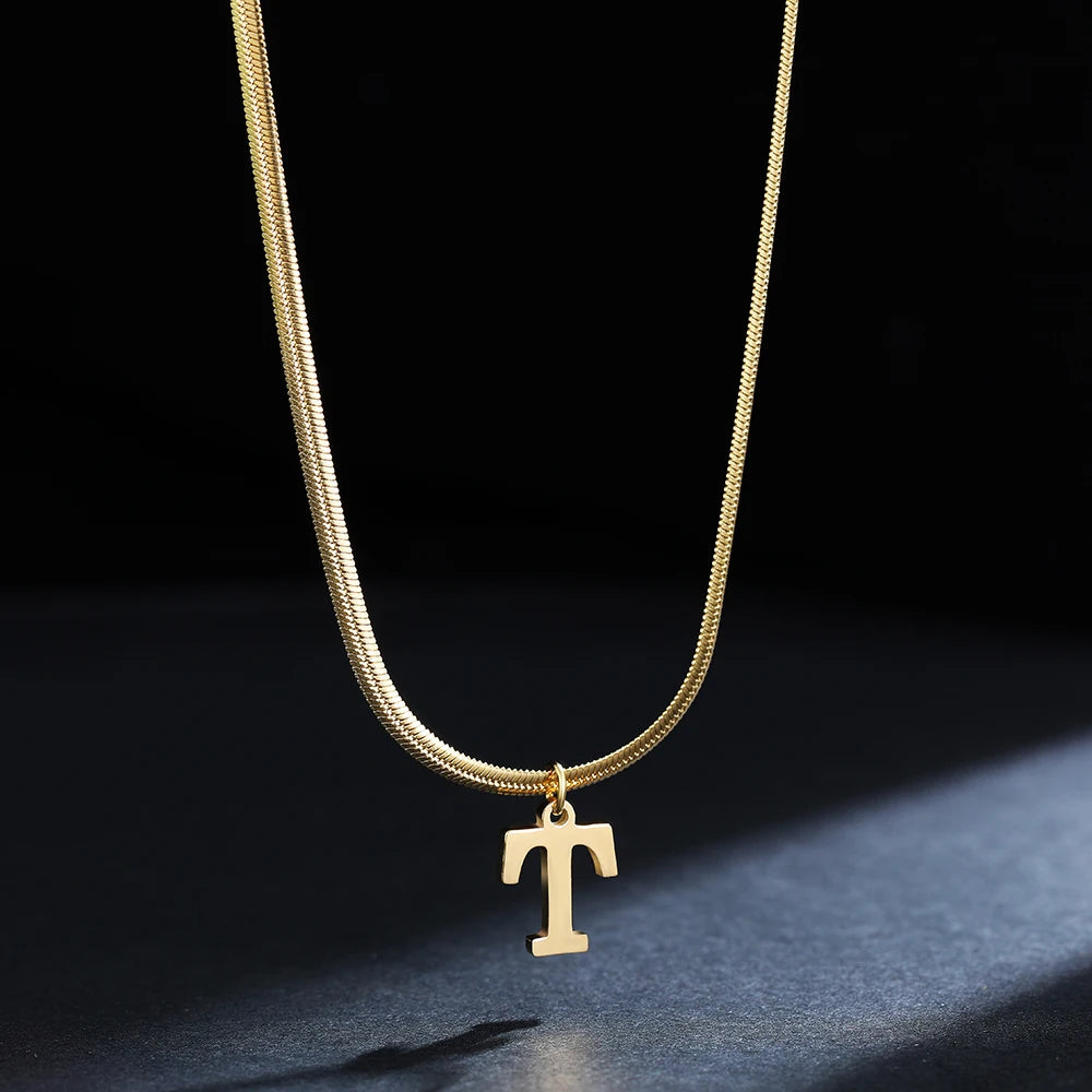 Collana iniziale A–Z in acciaio placcato oro con snake chain – pendente minimal su collare clavicolare