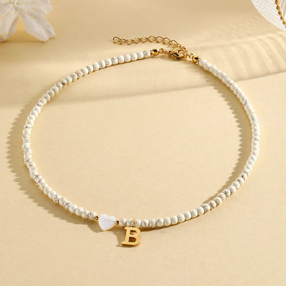 Choker boho con perline, cuore in conchiglia e iniziale in acciaio – collana personalizzata stile 2025
