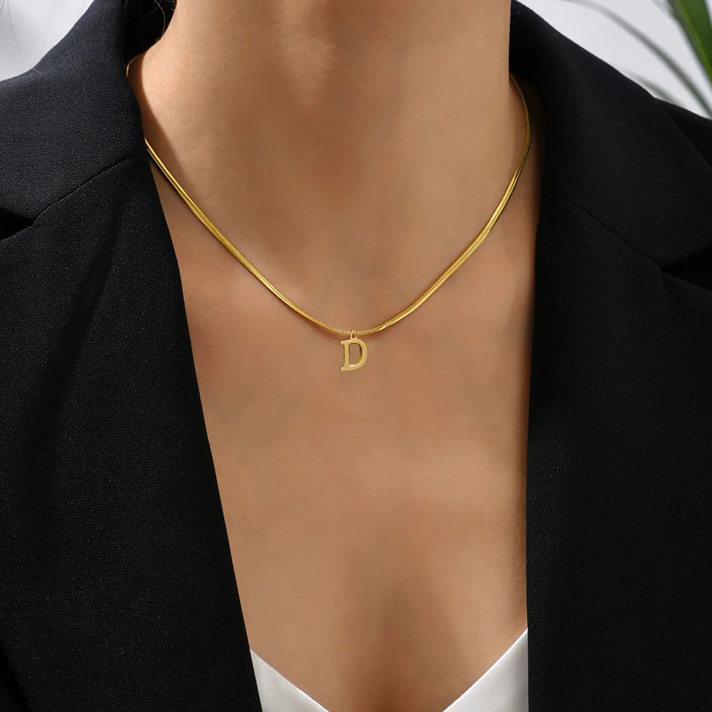 Collana iniziale A–Z in acciaio placcato oro con snake chain – pendente minimal su collare clavicolare