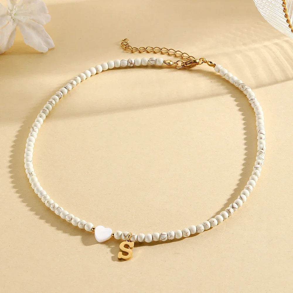 Choker boho con perline, cuore in conchiglia e iniziale in acciaio – collana personalizzata stile 2025