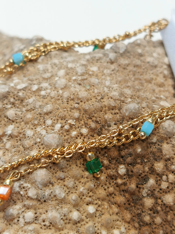 Cavigliera doppio filo con perline pendenti – eleganza fresca in color oro