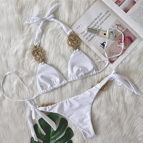Bikini Brasiliano ASKATE 2025 con nodi oro decorativi, top a triangolo wire‑free e slip low‑waist, elegante e femminile.

