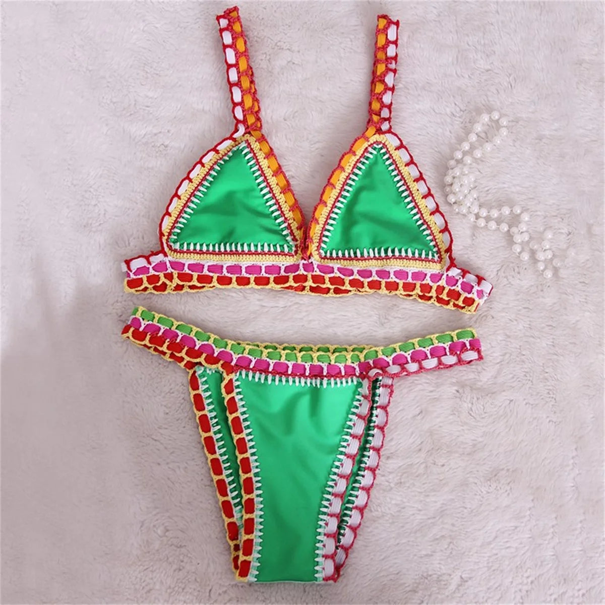 Bikini rosa micro brasiliano all’uncinetto con dettagli colorati top triangolo e bottom a vita bassa, per estiva 2025 artigianale.

