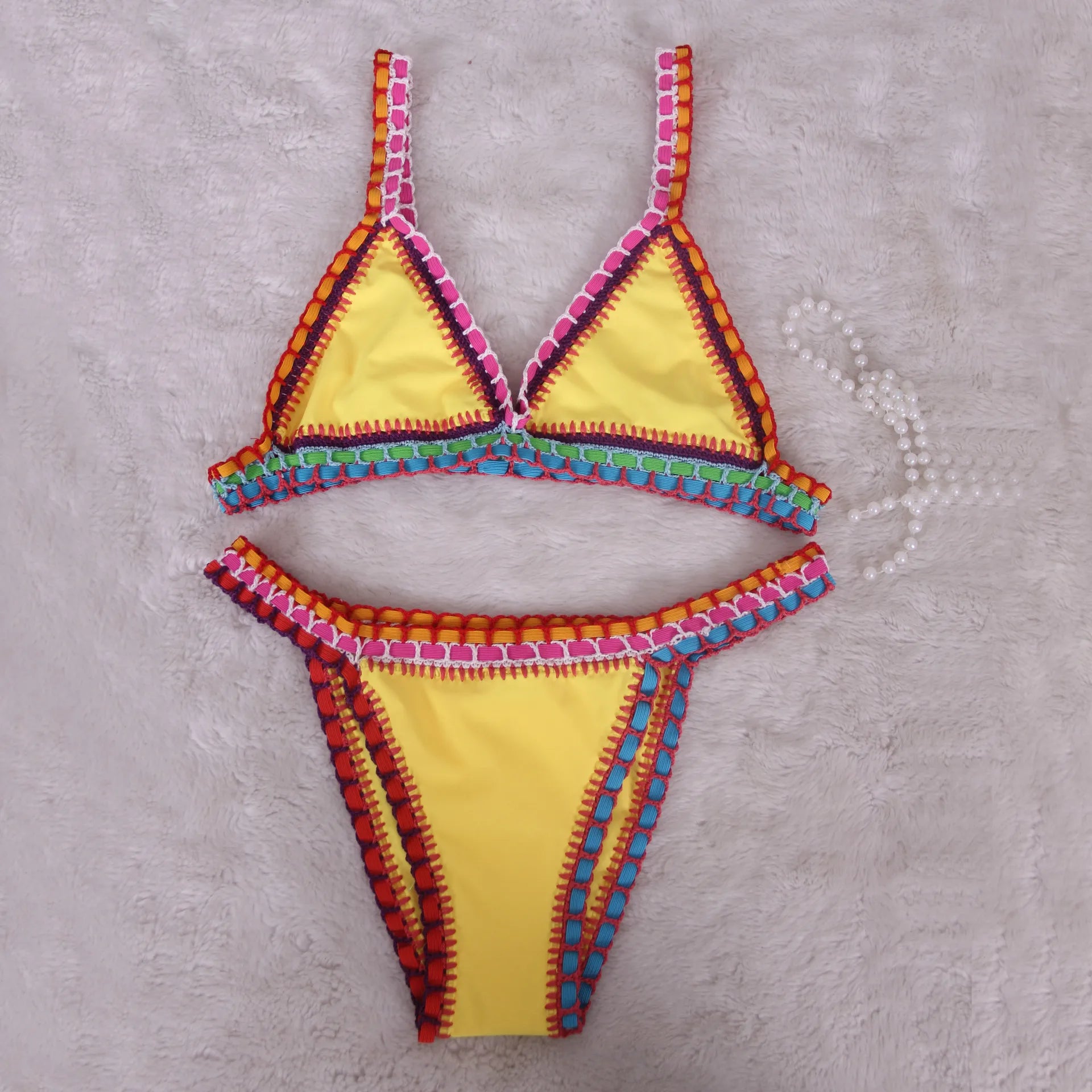 Bikini rosa micro brasiliano all’uncinetto con dettagli colorati top triangolo e bottom a vita bassa, per estiva 2025 artigianale.

