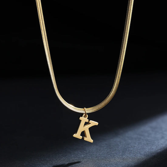 Collana iniziale A–Z in acciaio placcato oro con snake chain – pendente minimal su collare clavicolare