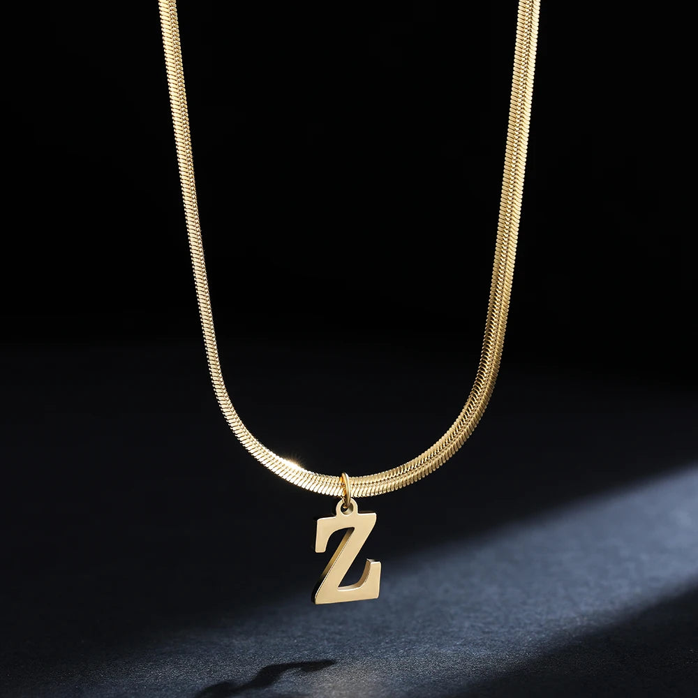 Collana iniziale A–Z in acciaio placcato oro con snake chain – pendente minimal su collare clavicolare