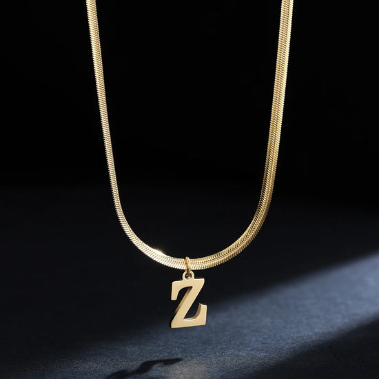 Collana iniziale A–Z in acciaio placcato oro con snake chain – pendente minimal su collare clavicolare