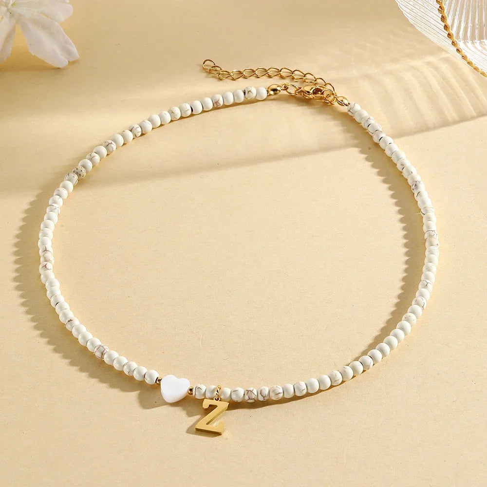 Choker boho con perline, cuore in conchiglia e iniziale in acciaio – collana personalizzata stile 2025