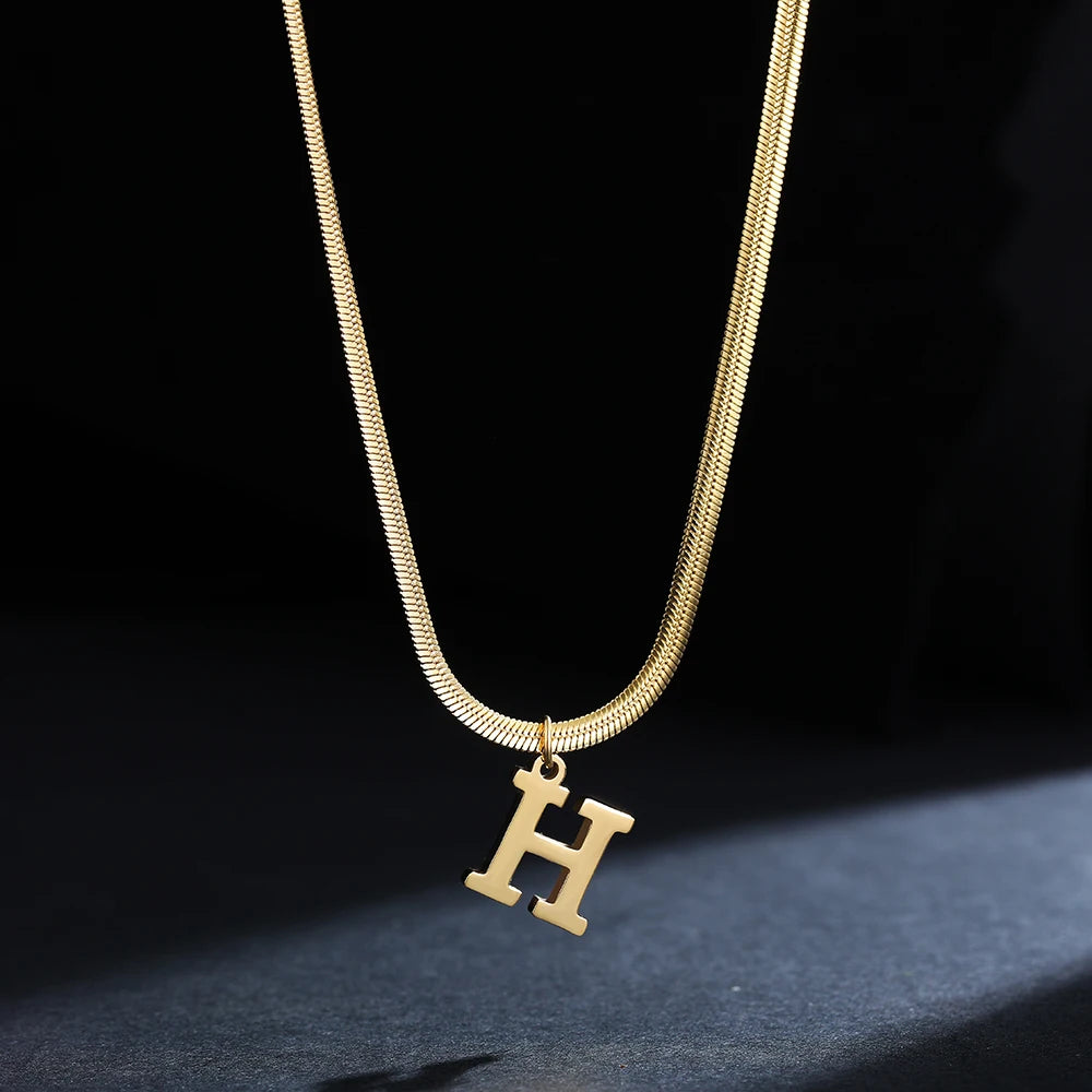 Collana iniziale A–Z in acciaio placcato oro con snake chain – pendente minimal su collare clavicolare