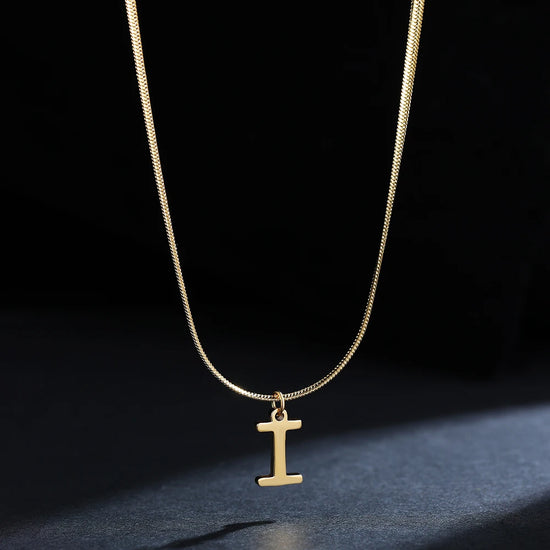 Collana iniziale A–Z in acciaio placcato oro con snake chain – pendente minimal su collare clavicolare