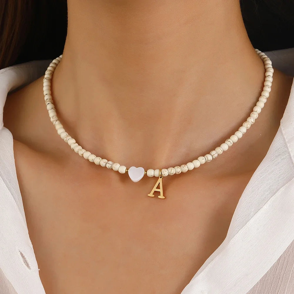 Choker boho con perline, cuore in conchiglia e iniziale in acciaio – collana personalizzata stile 2025
