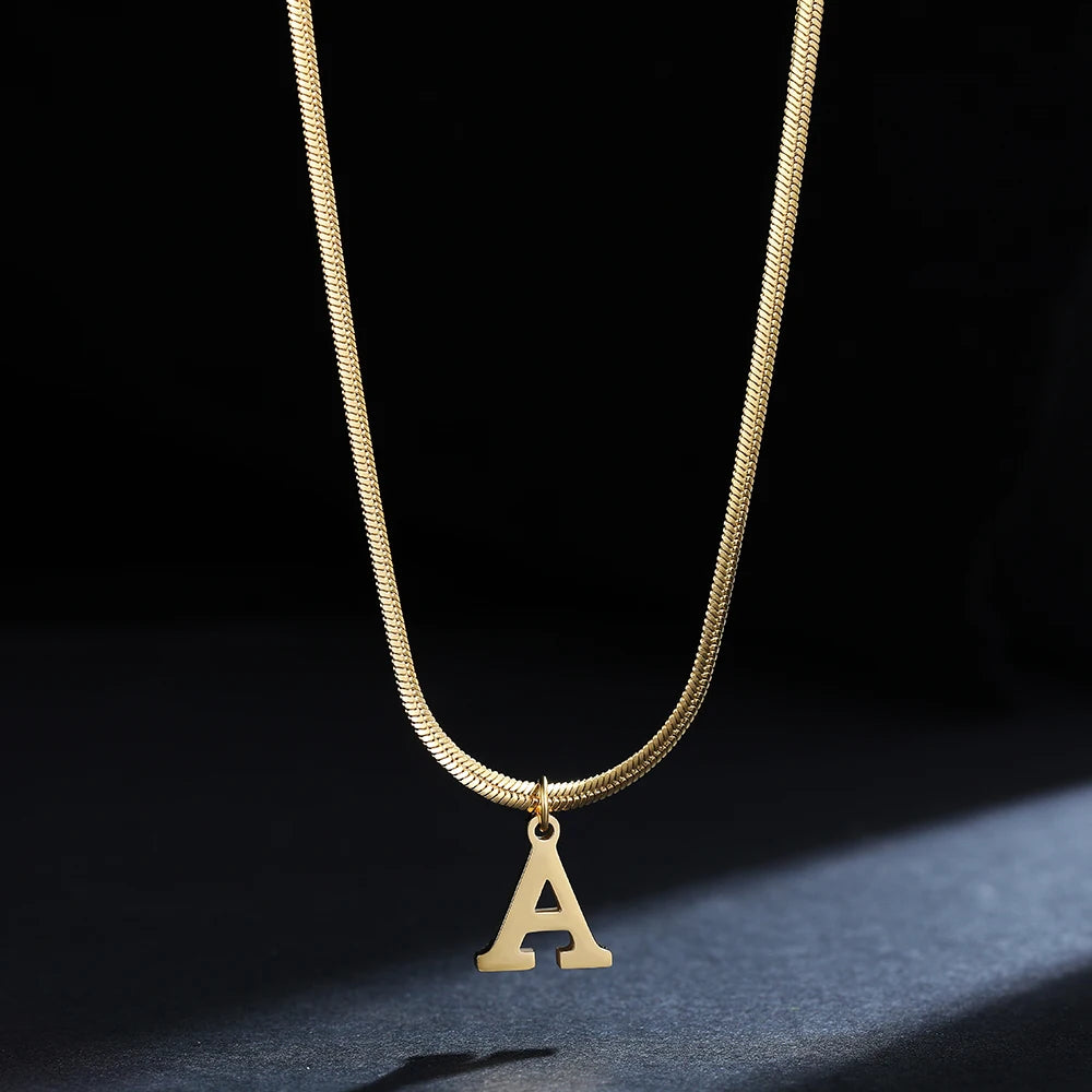 Collana iniziale A–Z in acciaio placcato oro con snake chain – pendente minimal su collare clavicolare