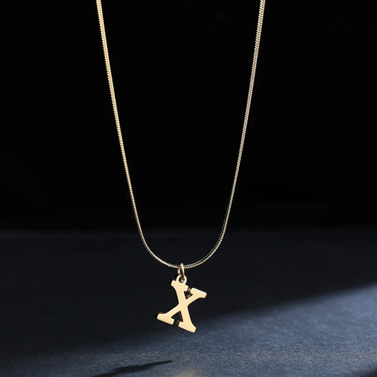 Collana iniziale A–Z in acciaio placcato oro con snake chain – pendente minimal su collare clavicolare