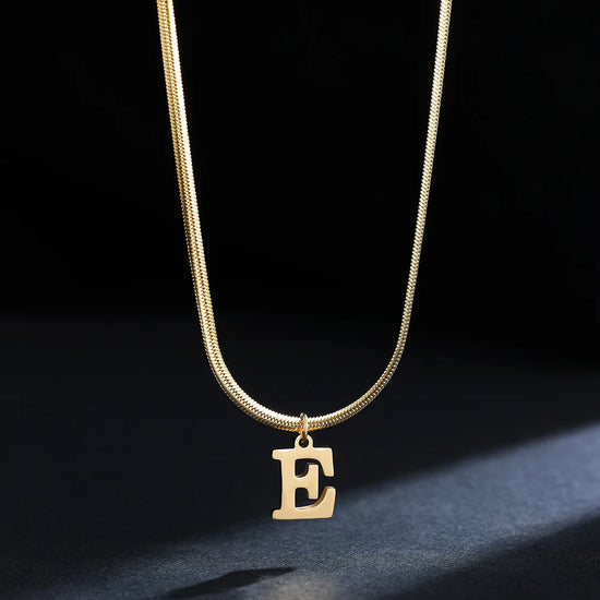 Collana iniziale A–Z in acciaio placcato oro con snake chain – pendente minimal su collare clavicolare