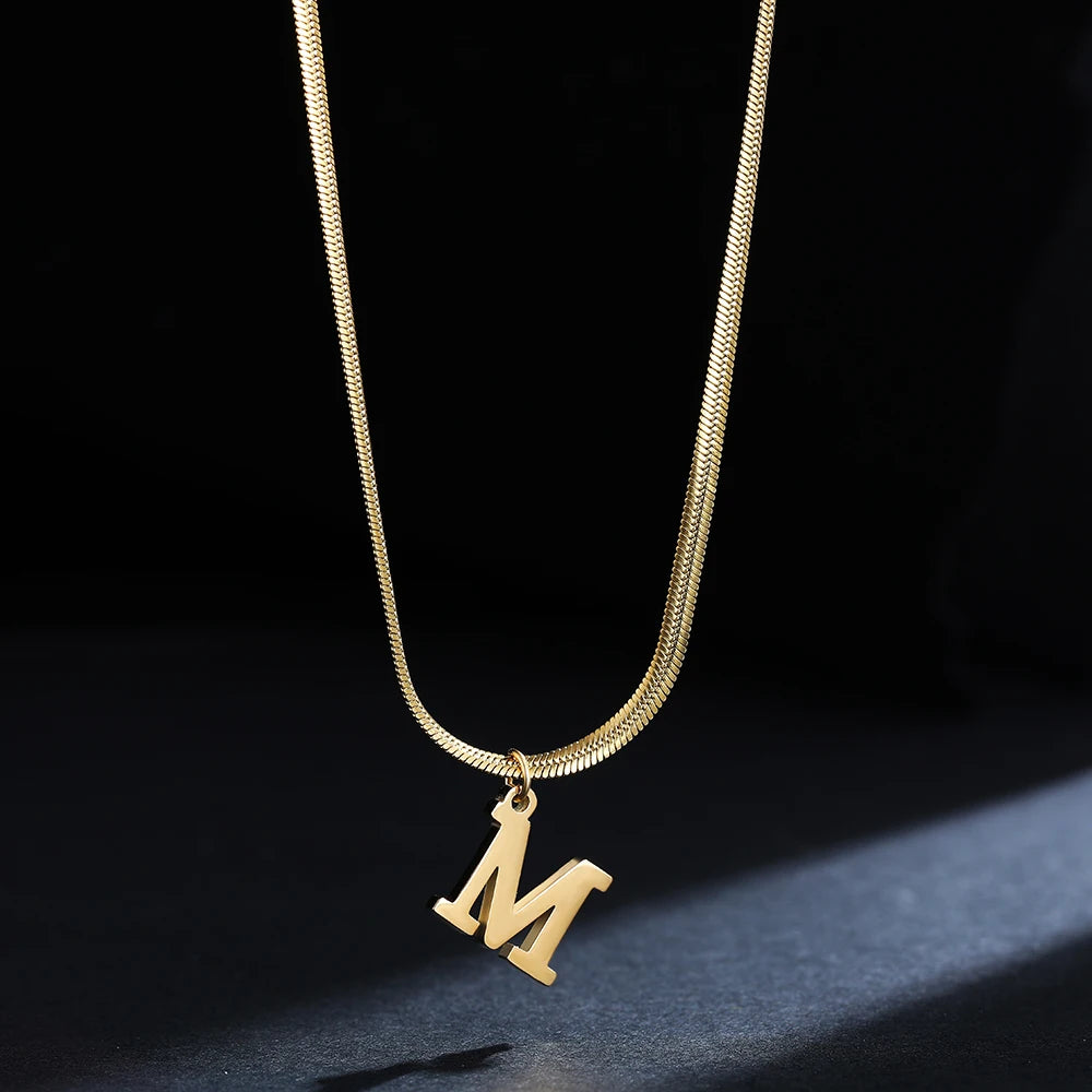 Collana iniziale A–Z in acciaio placcato oro con snake chain – pendente minimal su collare clavicolare