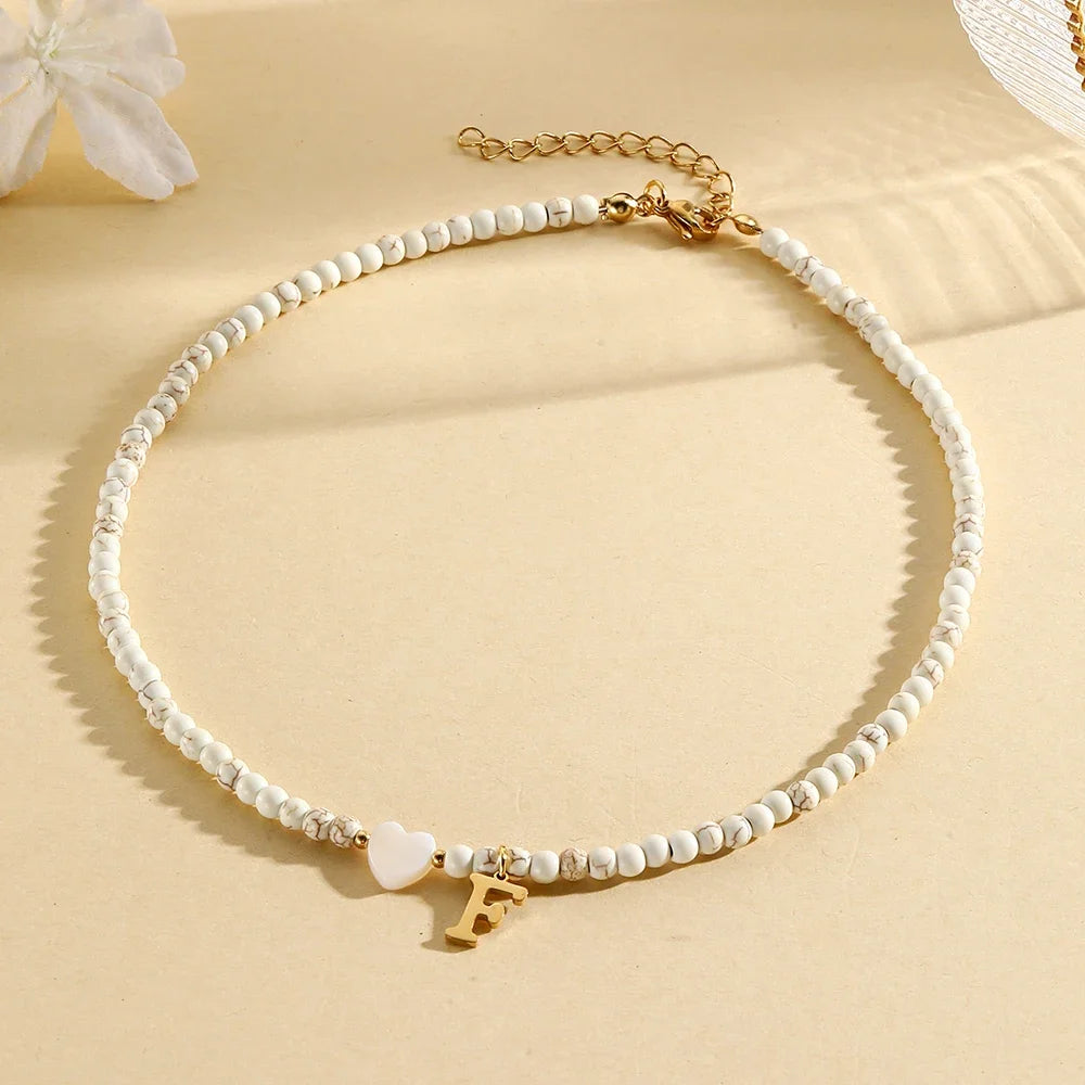 Choker boho con perline, cuore in conchiglia e iniziale in acciaio – collana personalizzata stile 2025