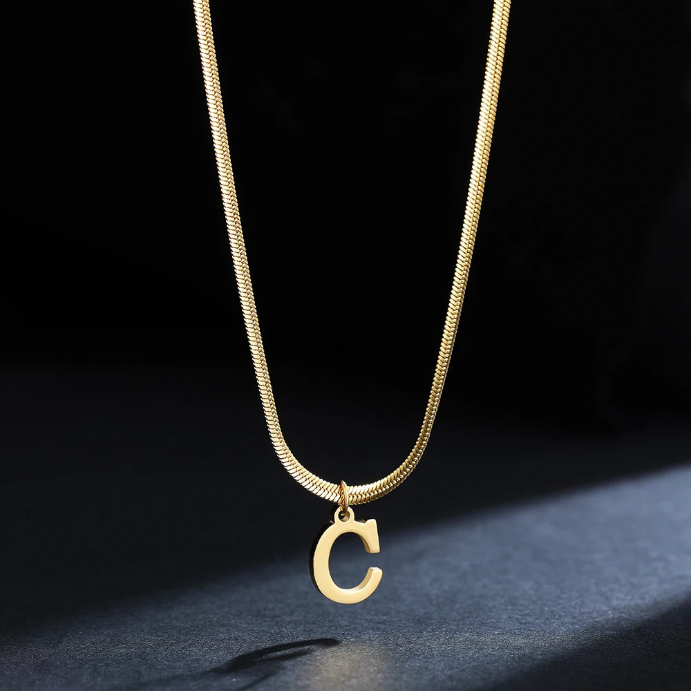 Collana iniziale A–Z in acciaio placcato oro con snake chain – pendente minimal su collare clavicolare