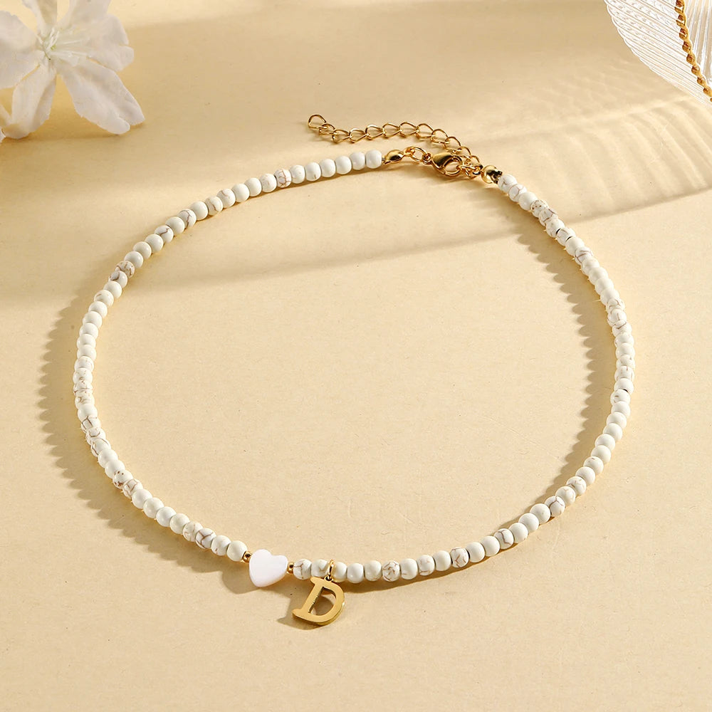 Choker boho con perline, cuore in conchiglia e iniziale in acciaio – collana personalizzata stile 2025