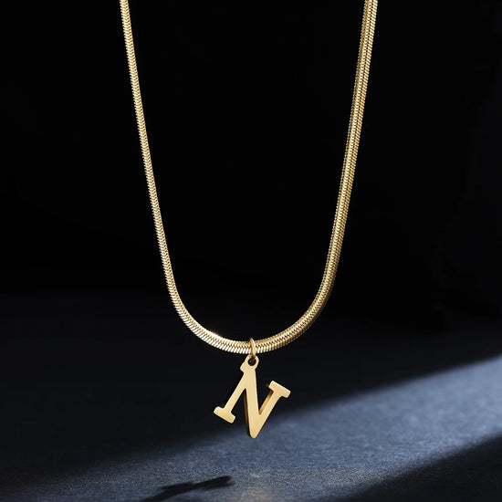 Collana iniziale A–Z in acciaio placcato oro con snake chain – pendente minimal su collare clavicolare