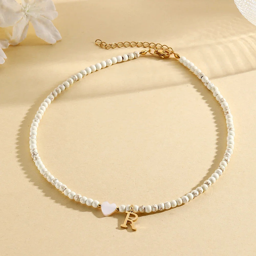 Choker boho con perline, cuore in conchiglia e iniziale in acciaio – collana personalizzata stile 2025