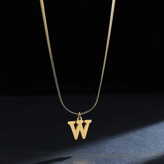 Collana iniziale A–Z in acciaio placcato oro con snake chain – pendente minimal su collare clavicolare