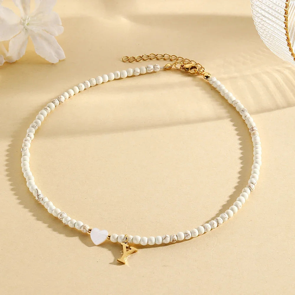 Choker boho con perline, cuore in conchiglia e iniziale in acciaio – collana personalizzata stile 2025