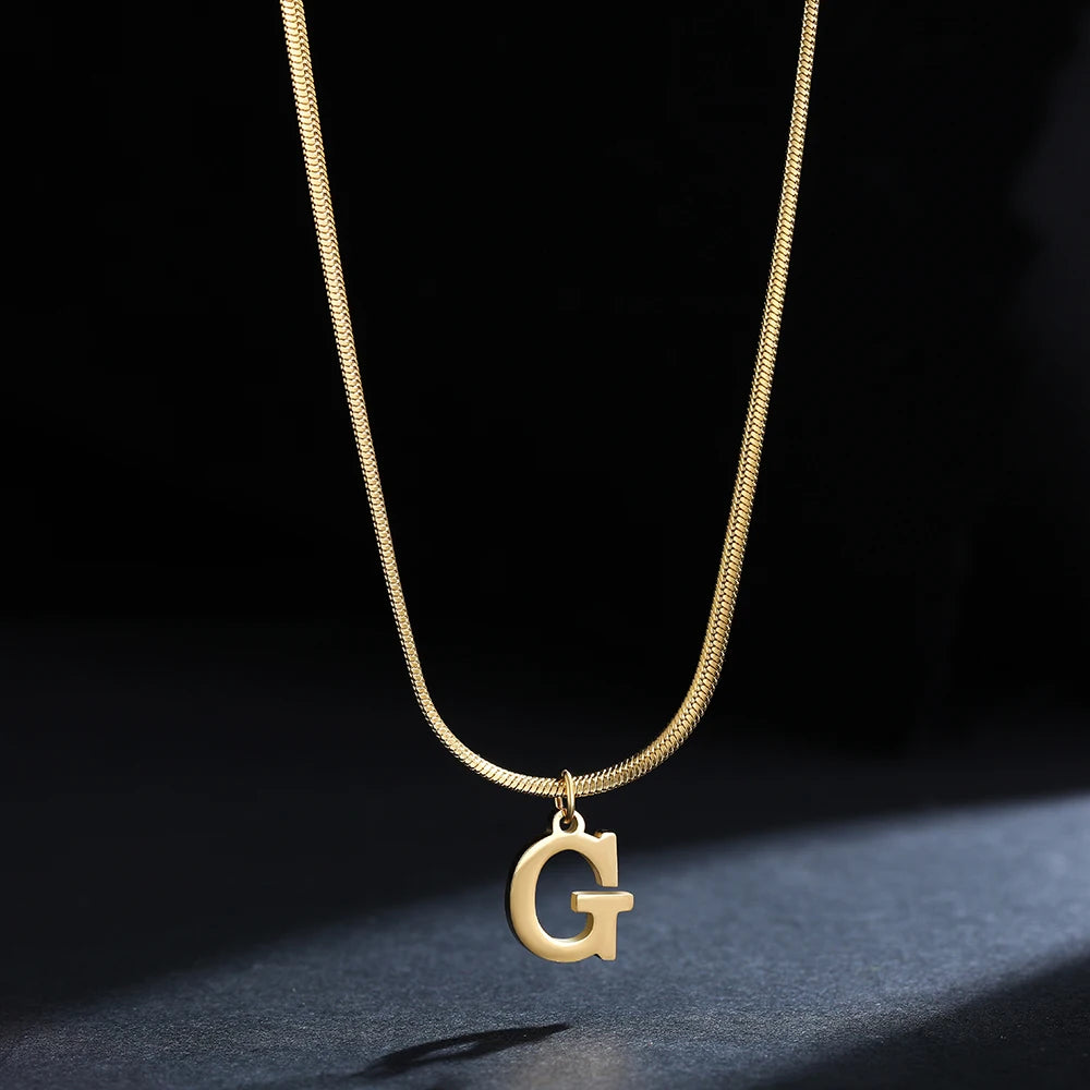 Collana iniziale A–Z in acciaio placcato oro con snake chain – pendente minimal su collare clavicolare
