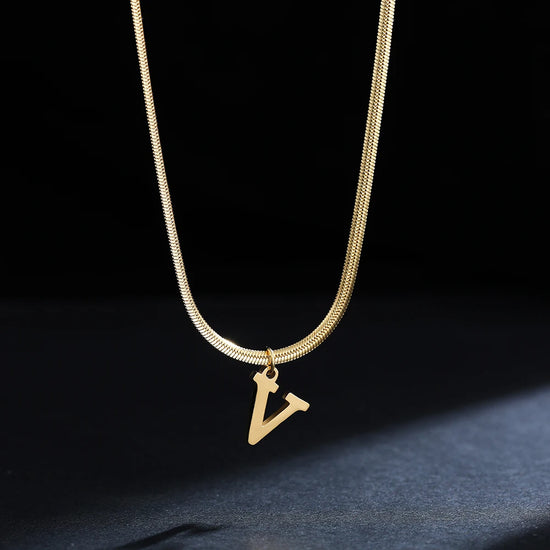 Collana iniziale A–Z in acciaio placcato oro con snake chain – pendente minimal su collare clavicolare