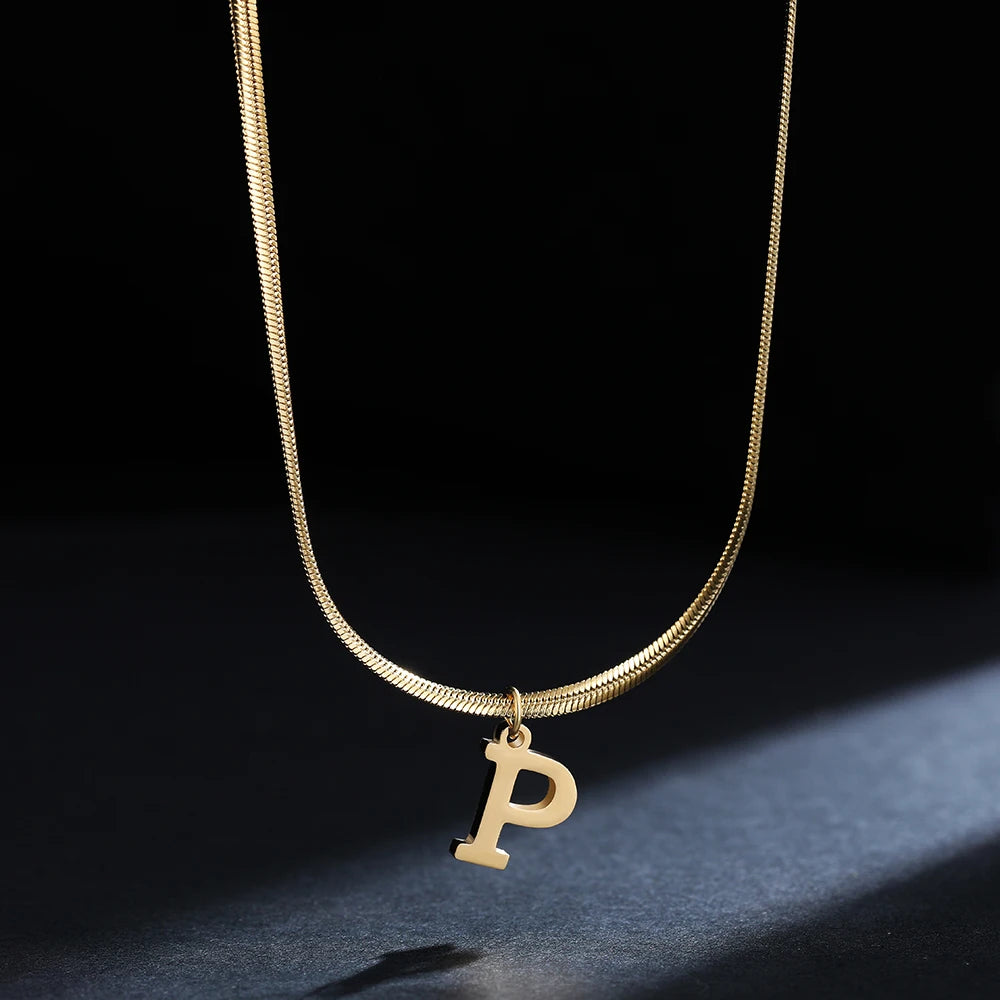 Collana iniziale A–Z in acciaio placcato oro con snake chain – pendente minimal su collare clavicolare