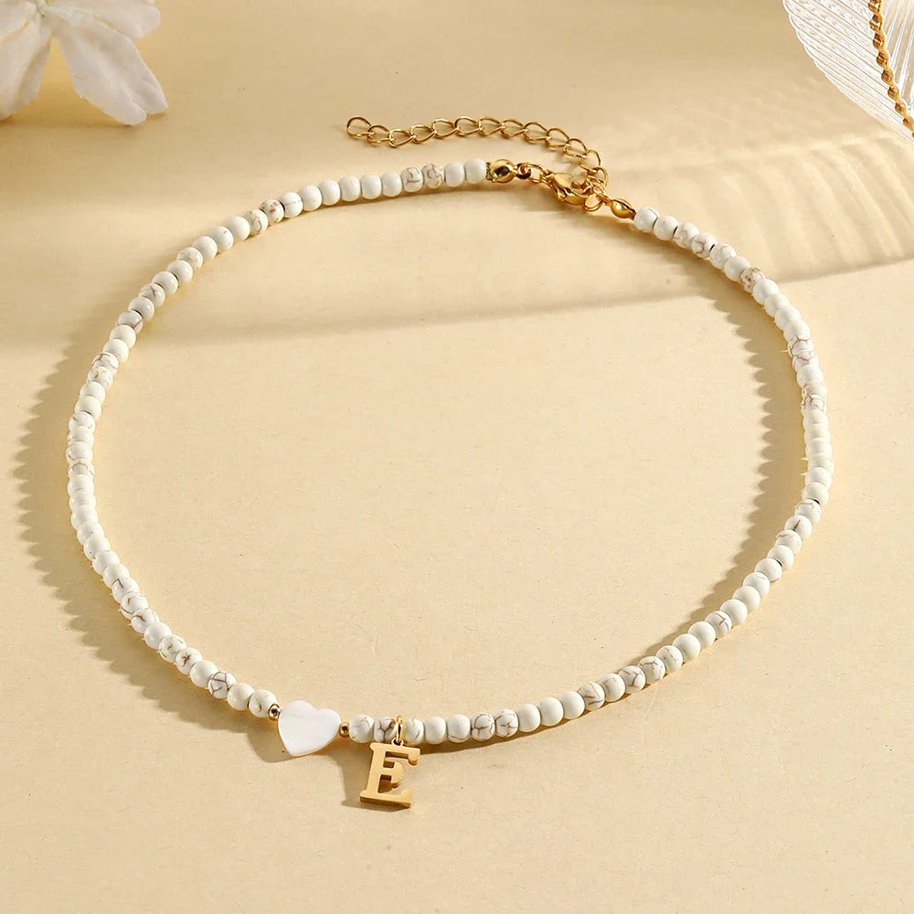 Choker boho con perline, cuore in conchiglia e iniziale in acciaio – collana personalizzata stile 2025