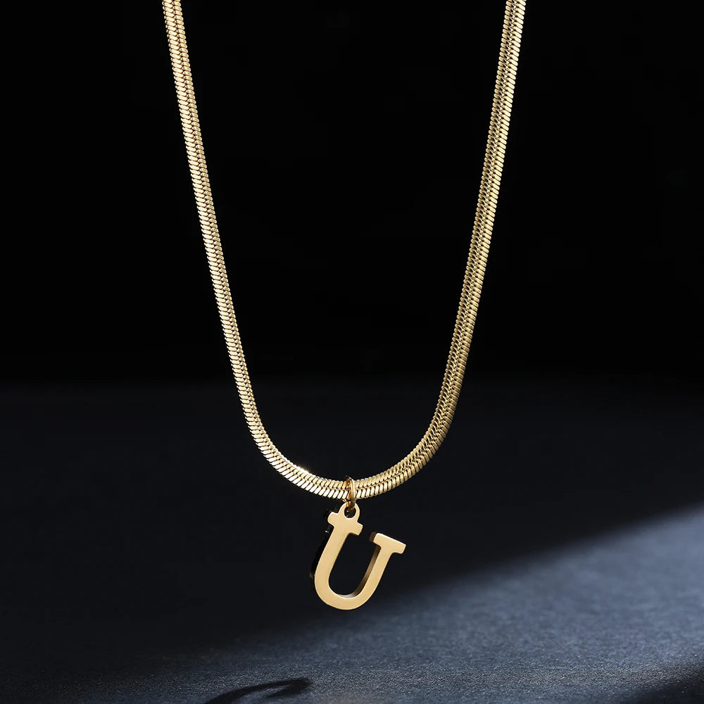 Collana iniziale A–Z in acciaio placcato oro con snake chain – pendente minimal su collare clavicolare
