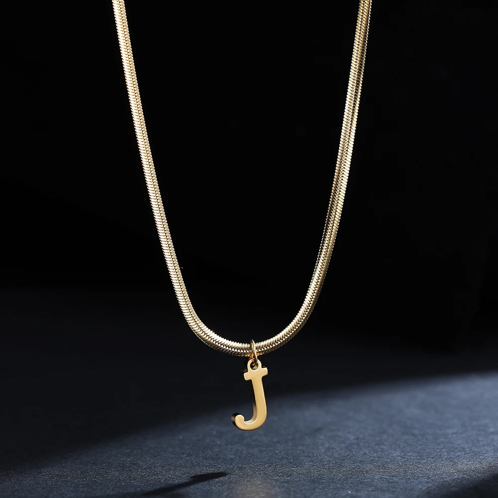 Collana iniziale A–Z in acciaio placcato oro con snake chain – pendente minimal su collare clavicolare