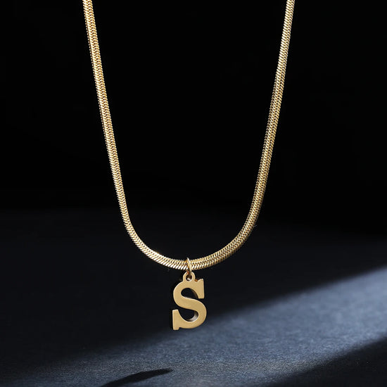 Collana iniziale A–Z in acciaio placcato oro con snake chain – pendente minimal su collare clavicolare