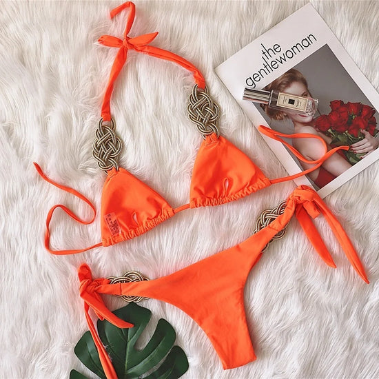 Bikini Brasiliano ASKATE 2025 con nodi oro decorativi, top a triangolo wire‑free e slip low‑waist, elegante e femminile.

