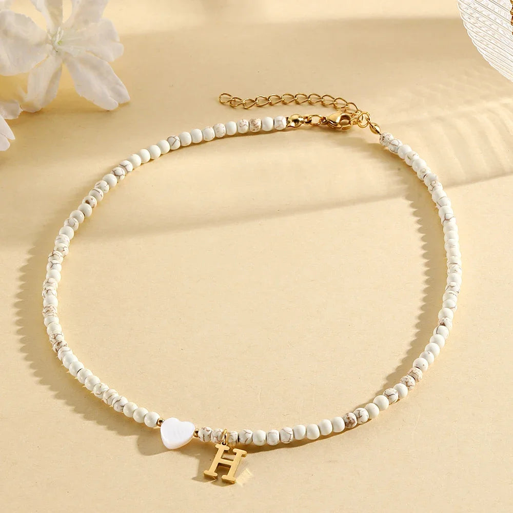 Choker boho con perline, cuore in conchiglia e iniziale in acciaio – collana personalizzata stile 2025