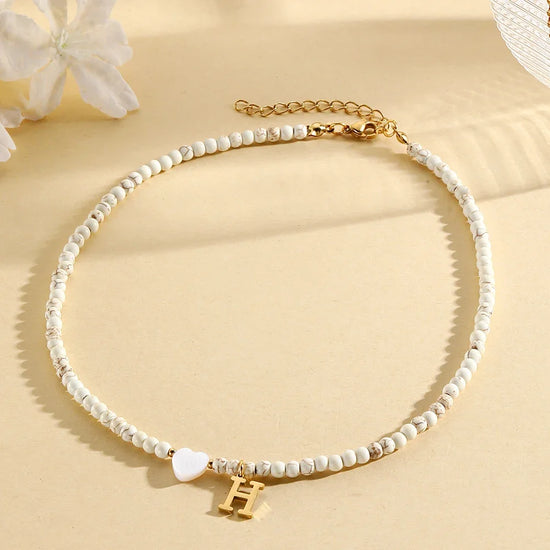Choker boho con perline, cuore in conchiglia e iniziale in acciaio – collana personalizzata stile 2025