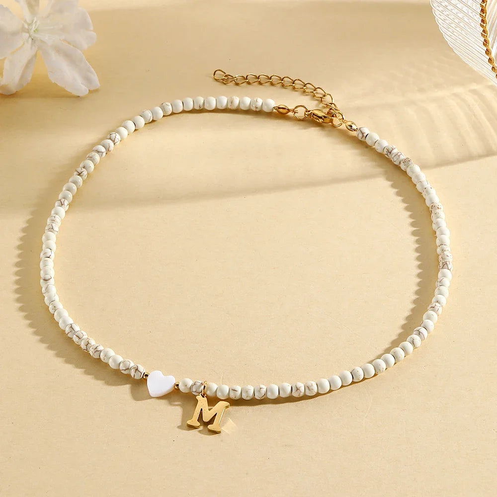 Choker boho con perline, cuore in conchiglia e iniziale in acciaio – collana personalizzata stile 2025