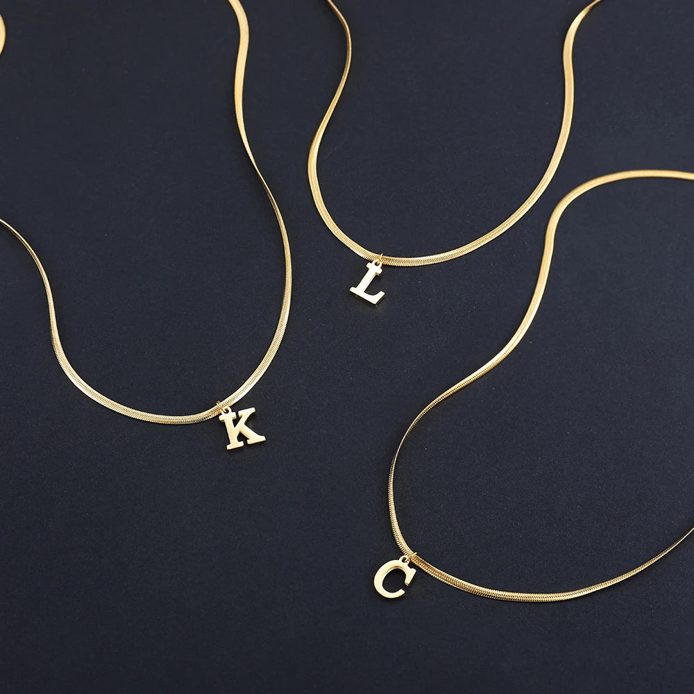 Collana iniziale A–Z in acciaio placcato oro con snake chain – pendente minimal su collare clavicolare