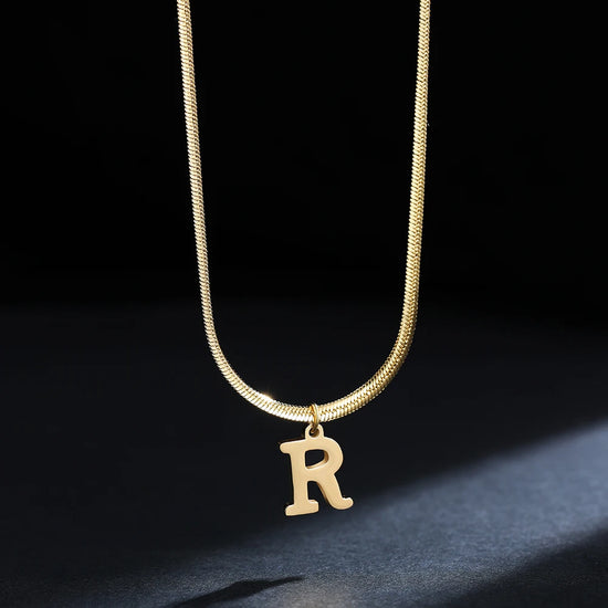 Collana iniziale A–Z in acciaio placcato oro con snake chain – pendente minimal su collare clavicolare