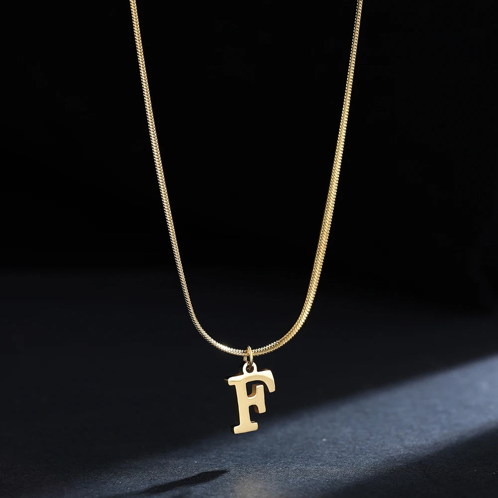 Collana iniziale A–Z in acciaio placcato oro con snake chain – pendente minimal su collare clavicolare