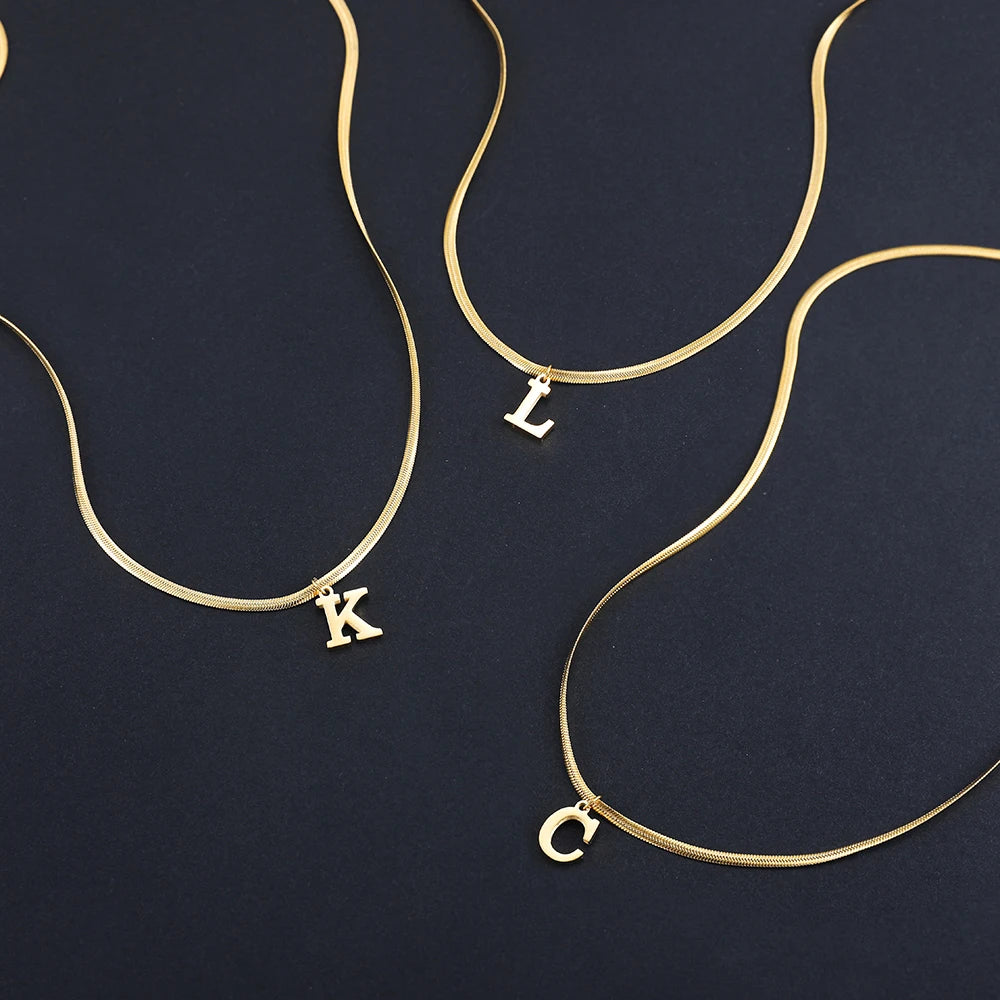 Collana iniziale A–Z in acciaio placcato oro con snake chain – pendente minimal su collare clavicolare